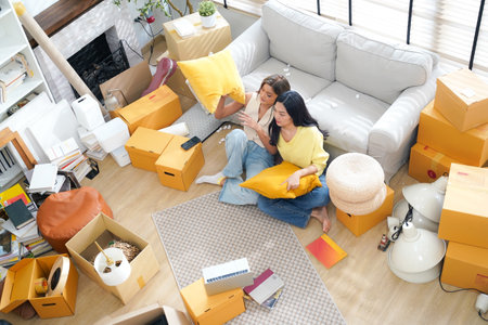 Young women and friend help moving home while packing boxes together and happy in new home.Â  Asia women investment real estate for living with familyの写真素材