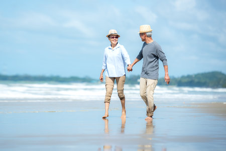 Asian Lifestyle senior couple walking chill on the beach happy in love romantic and relax time after retirement.Â  People tourism elderly family travel leisureの写真素材