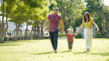 Happy family picnic and plying football in the park public on summer holiday.  Family relax and...