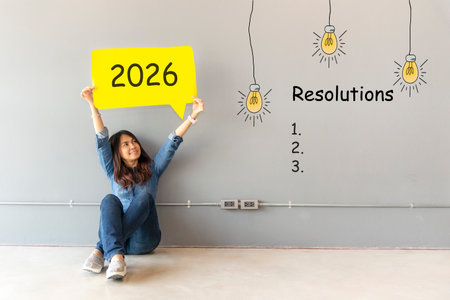 2026 resolutions with young woman pointing resolutions cheerful and happy new year with laptop on the sofa in living room.の写真素材
