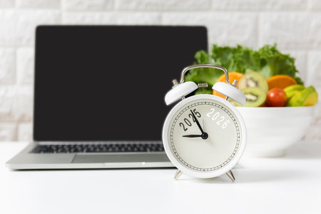 2026 and 2025 on alarm clock with workout planing for dieting. Sport exercise equipment workout andÂ gym nutrition fresh salad for fitness.の写真素材