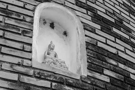 Small Buddha statue on the wall of pagodaの写真素材