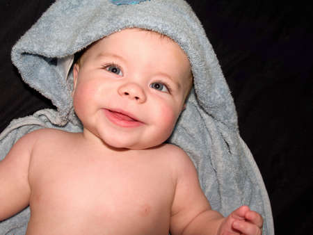 Happy young baby boy  in blue towel