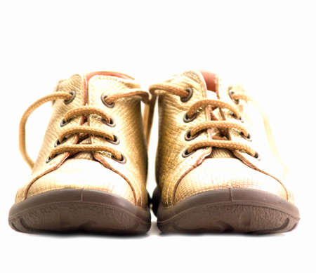 Cute golden baby shoes  isolated on whiteの写真素材