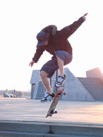 Catching some air - skateboarder doing a stunt in the cityの写真素材