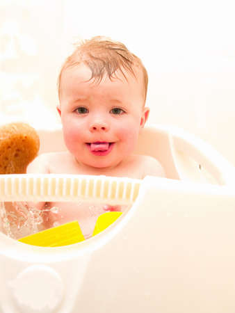 Happy baby boy  sitting in his bathの写真素材
