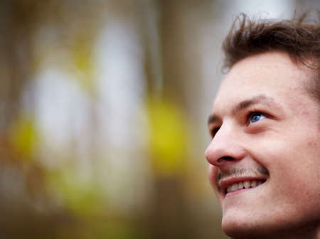 Happy young man looking up at copy space and smilingの写真素材