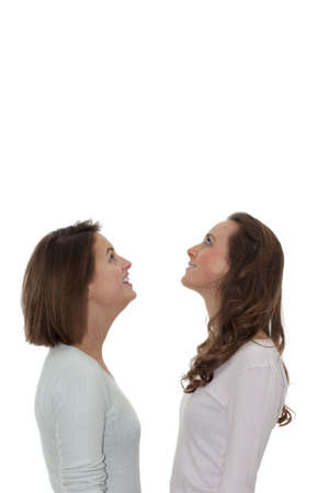 Two girls looking up at copy space on whiteの写真素材
