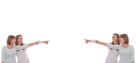 Four girls pointing at copy space in the middleの写真素材