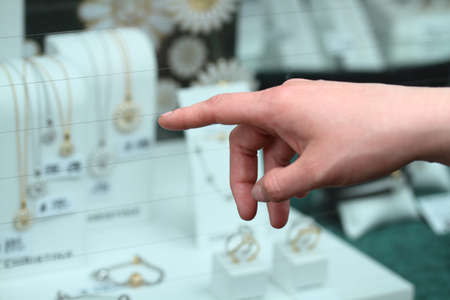 Womans hand pointing at jewelleryの写真素材