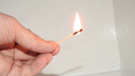 Burning wooden match in a man's hand.の写真素材