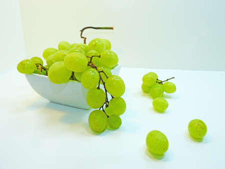 Fresh green grapes in plate isolated on white background