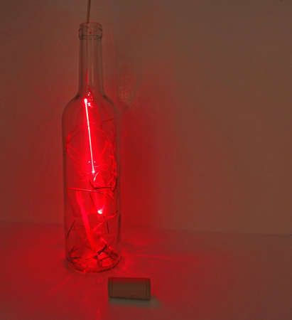 Glass bottle in abstraction with laser lights.の写真素材