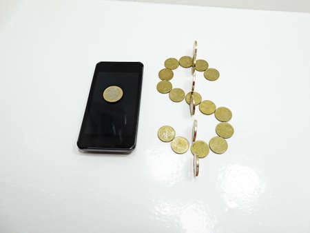 Smartphone on white background with some coins