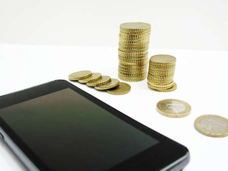 Smartphone on white background with some coins