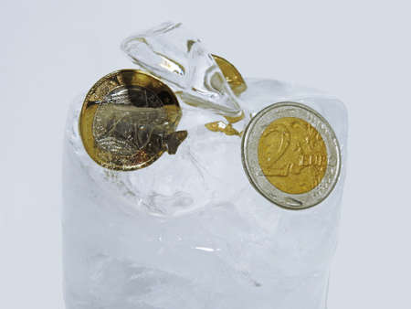 Cache euro coins in ice. Isolated on white background.の写真素材