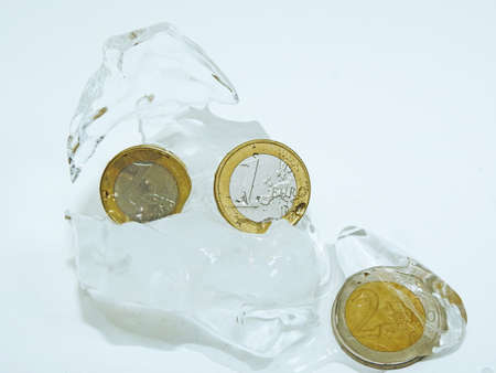 Cache euro coins in ice. Isolated on white background.の写真素材