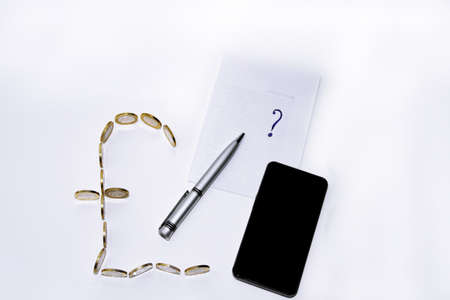 Pound symbol builds from coins with pen on white backgroundの写真素材
