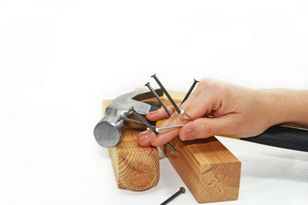 Woman hand with hammer and nails. Isolated on white background.の写真素材