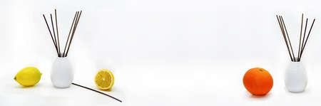 Aromatic sticks for home in white ceramic vase with fruits.の写真素材