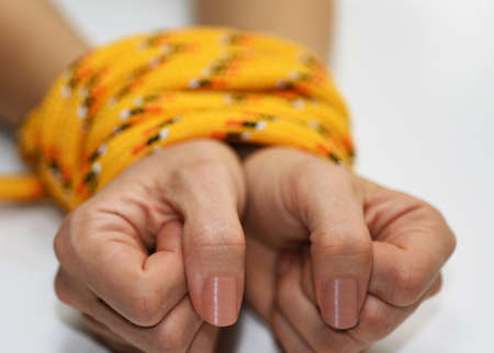 Woman hands tied with rope.の写真素材