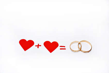 Abstract composition of weddings. Two red hearts and two golden rings.の写真素材