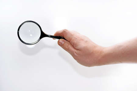 Mans hand with magnifying glass.の写真素材