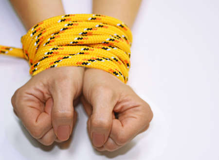 Woman hands tied with rope.の写真素材