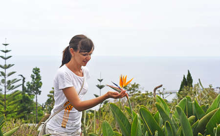 Young woman with flower of Strelitzia on Madeira's islandの写真素材
