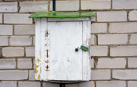 Old electric wooden box on a brick wall.の写真素材