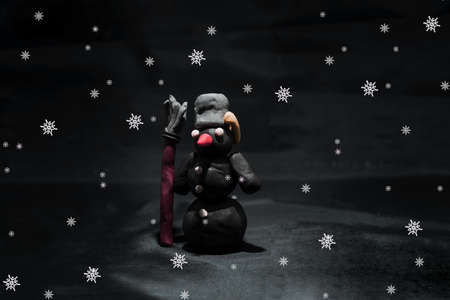 Black Friday abstract photo. Happy Merry Christmas. Snowman made from plasticine on black background.の写真素材