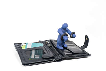 Theft and fraud. Small figure made from Play Clay with purse isolated on white background.