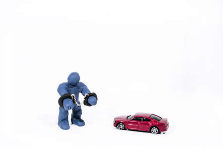 Small blue figure in handcuffs. Made from Play Clay. Isolated on white background.