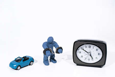 Small blue figure in handcuffs. Made from Play Clay. Isolated on white background.の写真素材