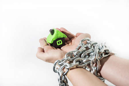 Abstract idea of property and credits. Problems with property, house, money. Small house made from Clay in mans hands.の写真素材