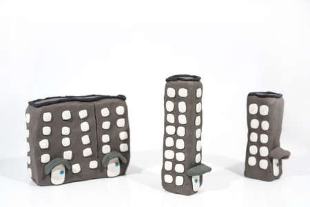 Abstract photo of buildings works. Figures made from Play Clay. Isolated on white background.