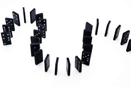 Falling domino abstraction. Black domino isolated on white background.の写真素材