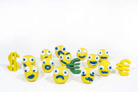Abstract photo with yellow smileys made from Play Clay. People mass emotions. Isolated on white background.の写真素材