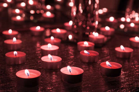 Burring candles on decorative glass. Dark background. Abstract photo.の写真素材