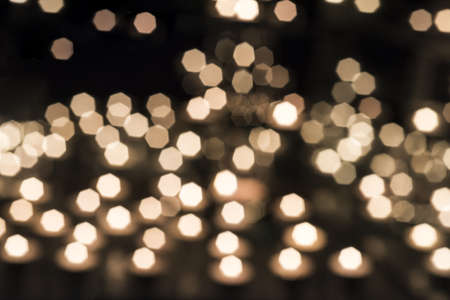 Burring candles on decorative glass. Dark background. Abstract photo.の写真素材