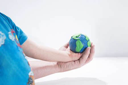 Small Earth model with human hands. Abstract composition of peace.の写真素材