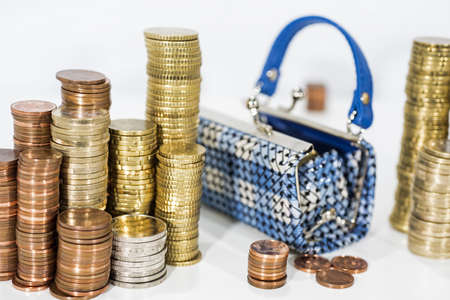 A lot of coins on white table with black purse. Abstract photo of money.の写真素材