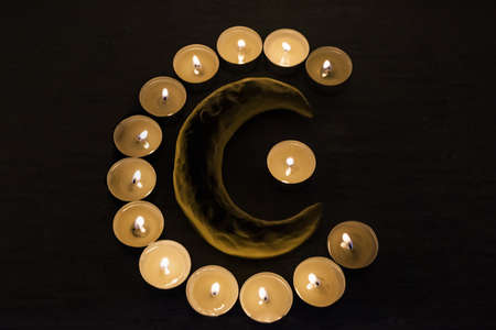 Symbols of Islam. Candle lights on black background. Abstract isolated photo.