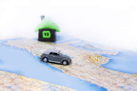 Abstract idea of rent a car. Small car on map. Abstract travel photo.の写真素材