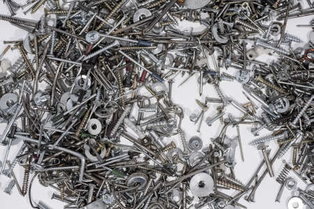 A lot of cogs, screws, bolts and moods on a white background. Abstract photo.