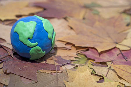Small Earth model on autumn leaves Abstract composition of peace.