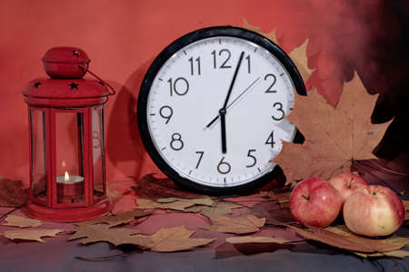 Red lantern lamp with candle and apples on red background.