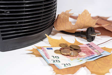 Money for heating bills with black heater on whiteの写真素材