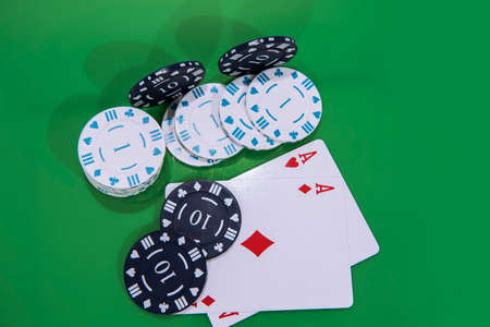 Cards and chips on green and yellow casino table. Abstract casino gambling photo.