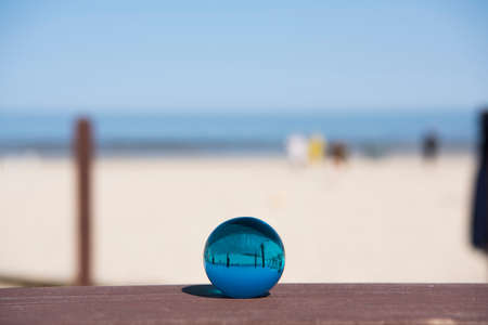 Glass sphere at the beach. Sunny summer day.